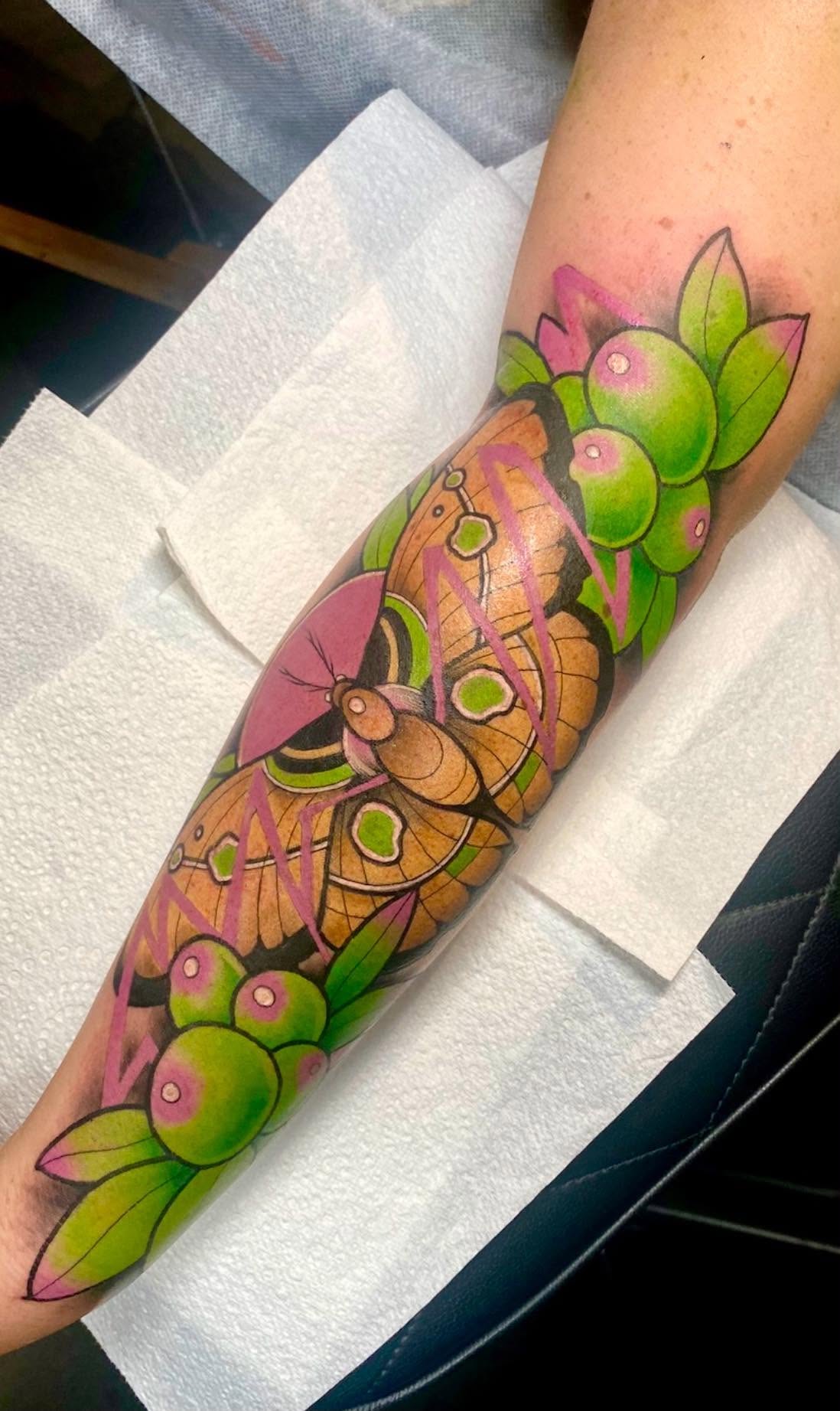 Neo-traditional colour luna moth with green berries and leaves forearm tattoo by Love and Chaos Tattoo Gallery, Mudgee NSW